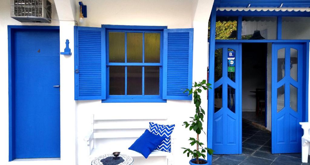 una puerta azul y ventanas en un edificio blanco en Pousada Costa Verde, en Abraão