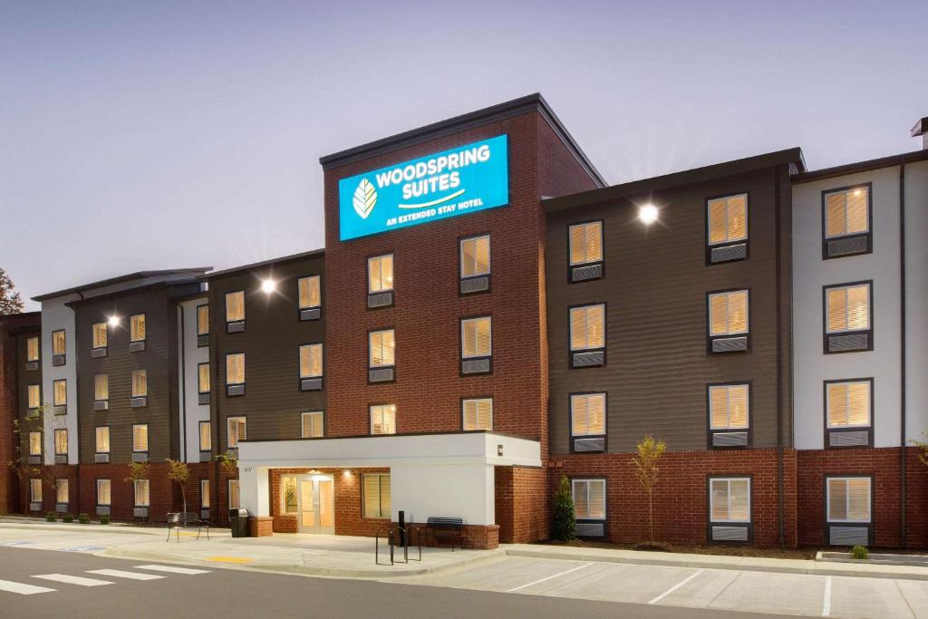 a large brick building with a blue sign on it at Wood Spring Suites Washington DC East Arena Drive in Hyattsville