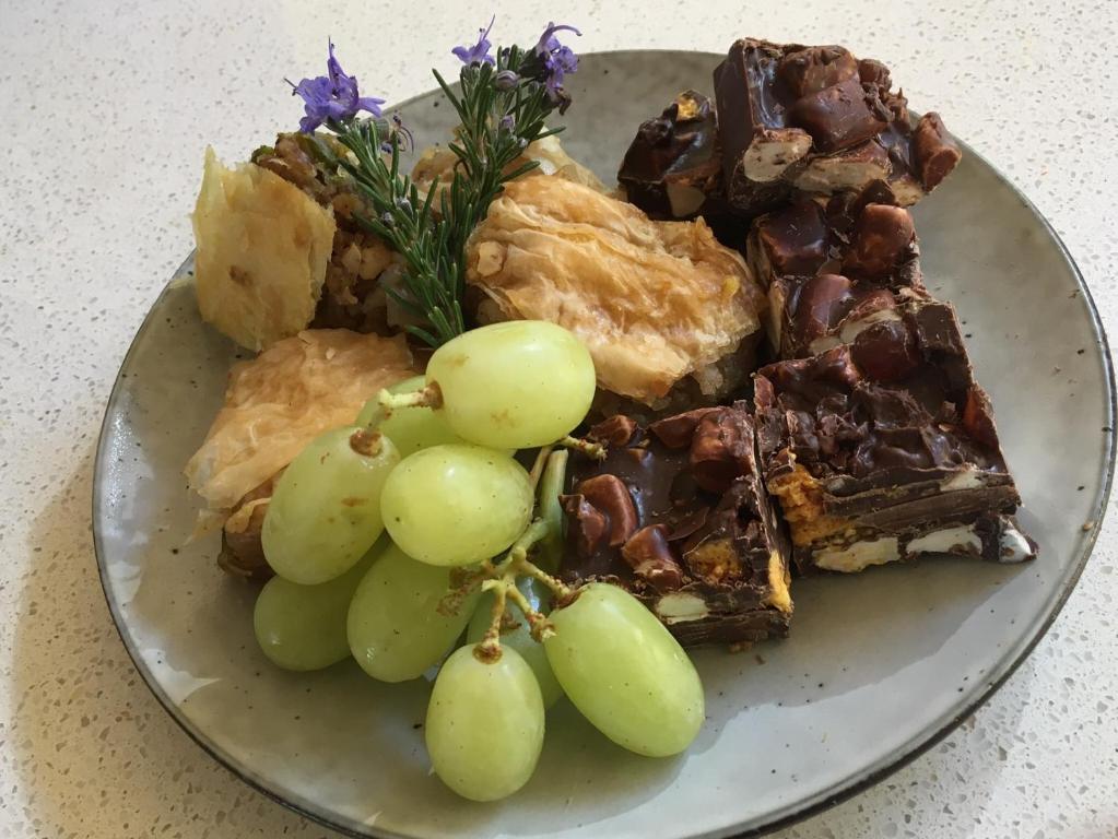 a plate of food with grapes and desserts on it at Stephanie’s Country Cottages in Drummond