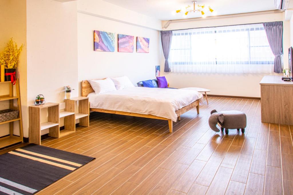 a bedroom with a bed and a table and a window at ioio in Tainan