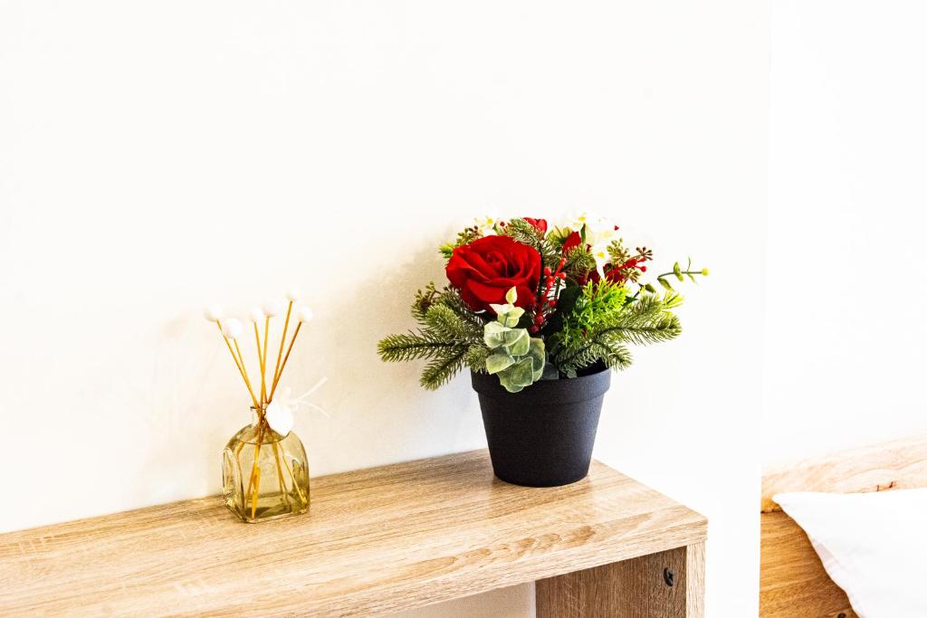 a vase with a red rose sitting on a wooden table at ioio in Tainan