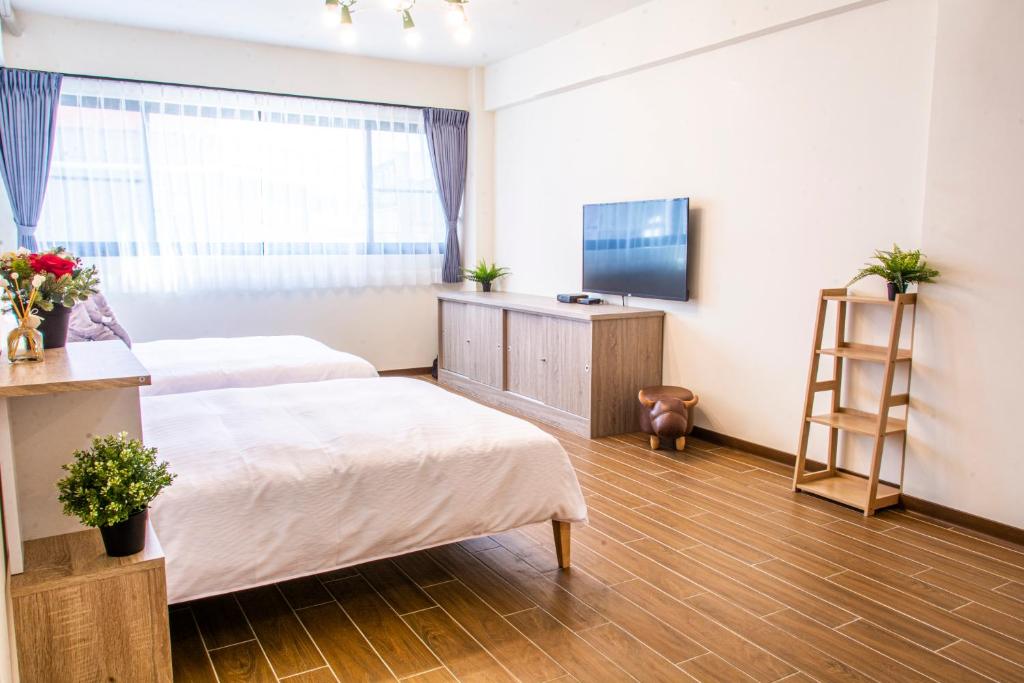 a hotel room with two beds and a television at ioio in Tainan