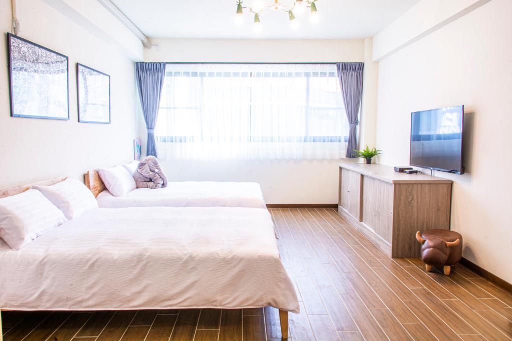 a hotel room with two beds and a television at ioio in Tainan