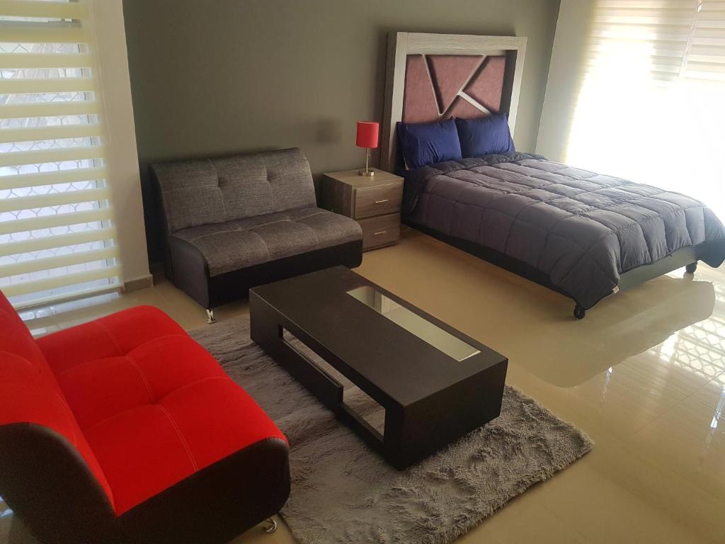 a bedroom with a bed and a chair and a couch at La Roma Zona Tec - San Pedro Zona Valle Ote. in Monterrey