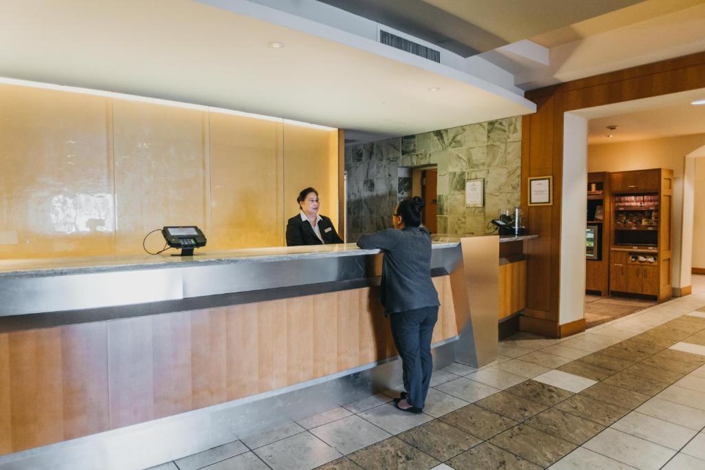 a woman standing at a counter in a hotel lobby at Crowne Plaza San Francisco Airport, an IHG Hotel in Burlingame