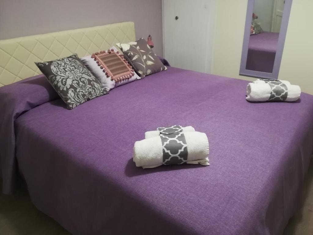 dwa łóżka z fioletową pościelą i poduszkami na nich w obiekcie Persiane al Cassaro w mieście Palermo