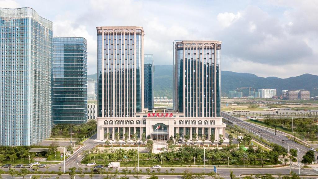un groupe de grands bâtiments dans une ville dans l'établissement Zhuhai Hengqin Qianyuan Hotel, à Zhuhai