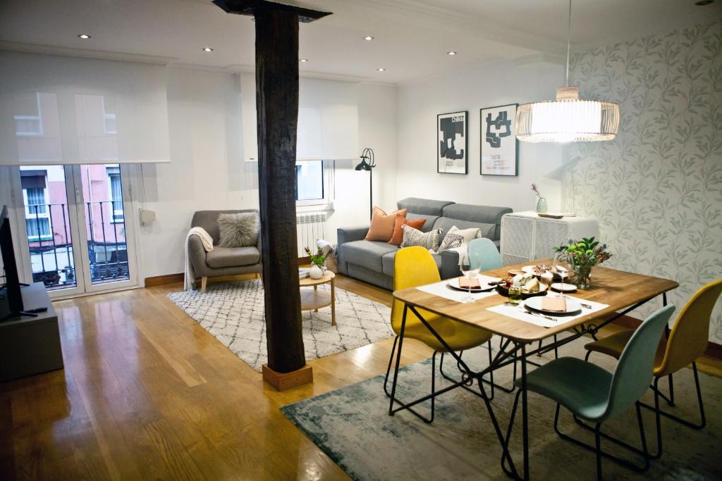 sala de estar con mesa y sofá en ZUBIGANE apartamento junto a la Ría & Parking, en Bilbao