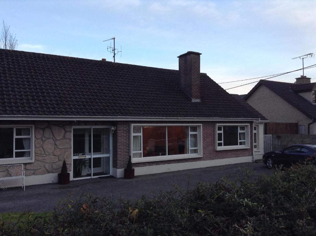 una casa con techo y un coche aparcado delante en Rodini B&B, en Kilkenny