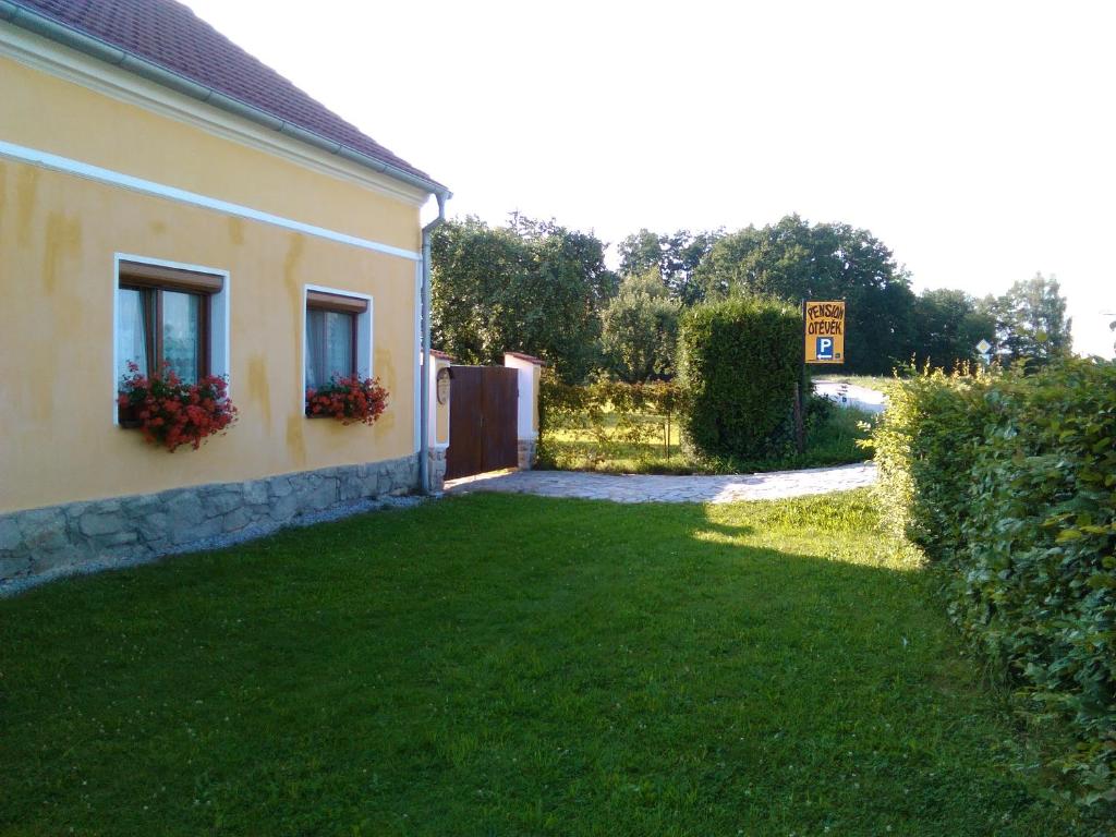 un patio junto a una casa con una puerta y flores en Pension Otěvěk, en Trhové Sviny