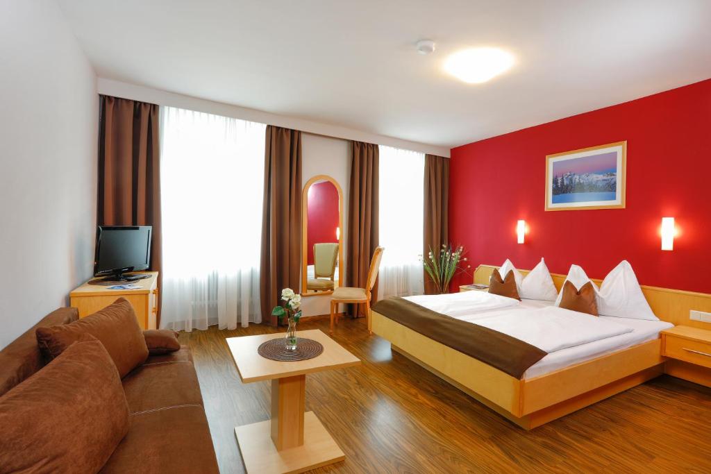 een hotelkamer met een bed en een bank bij Pension Sendlhofer in Radstadt