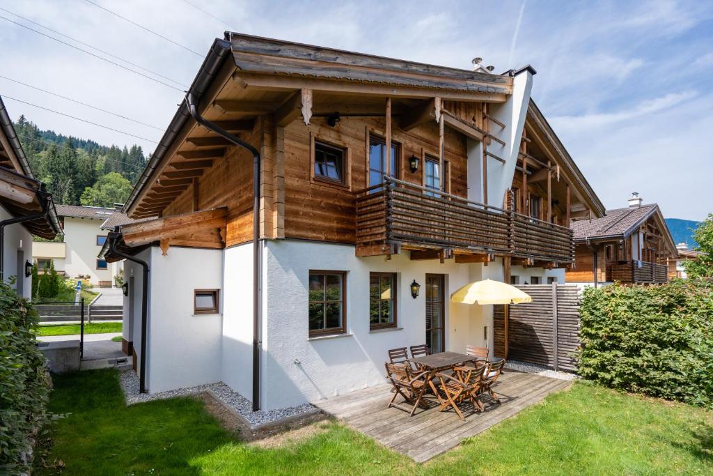 una casa con terrazza e tavolo di Alpenchalets Flachauer Gutshof a Flachau