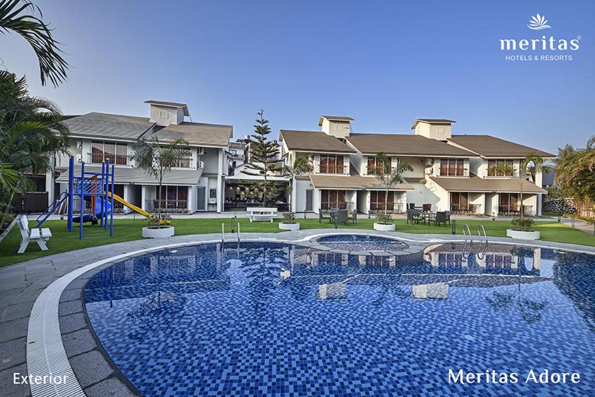 a large swimming pool in front of a house at Meritas Adore Resort in Lonavala