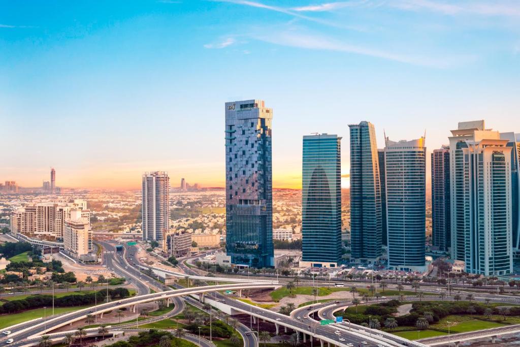 Taj Jumeirah Lakes Towers في دبي: أفق المدينة مع المباني الطويلة والطريق السريع