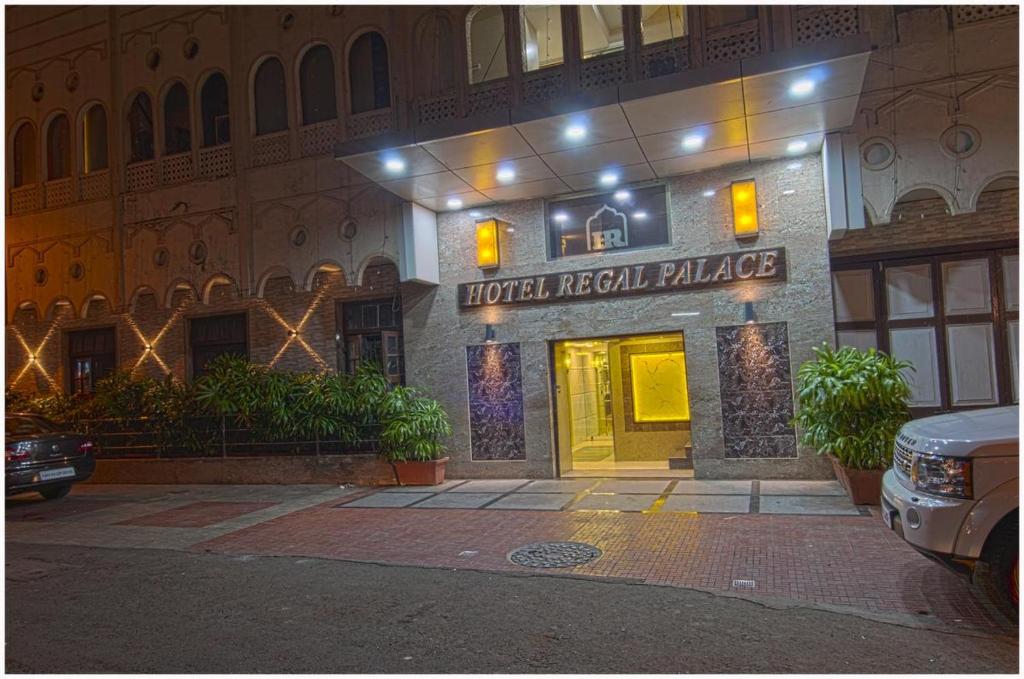 a hotel lobby with a hoteleli palace at night at Hotel Regal Palace in Mumbai