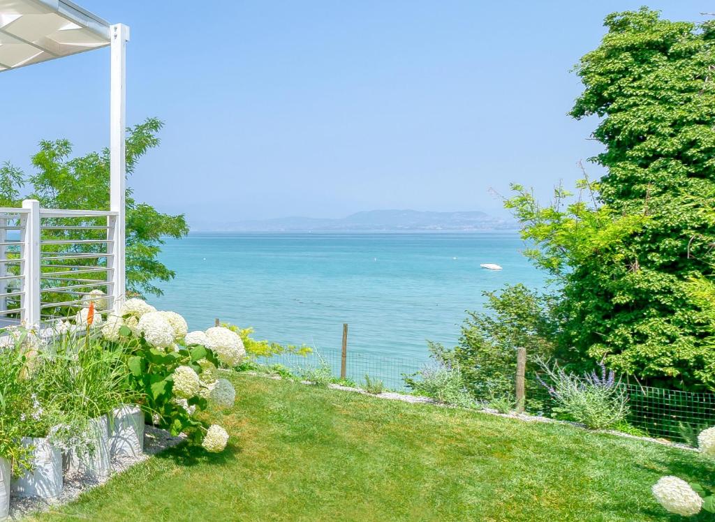 een tuin met uitzicht op het water bij San Benedetto Camping Relais in Peschiera del Garda