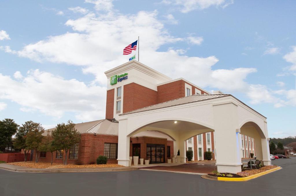 a building with an american flag on top of it at Holiday Inn Express Fredericksburg - Southpoint, an IHG Hotel in Fredericksburg
