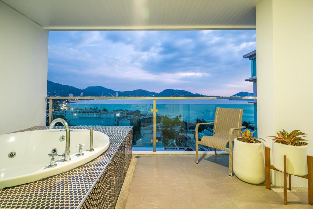 a bathroom with a tub and a view of the ocean at Baycliff Residence by Lofty in Patong Beach