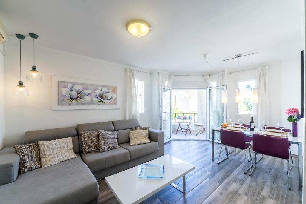 een woonkamer met een bank en een tafel bij Apartment Gual 1 By SunVillas Mallorca in Port de Pollença