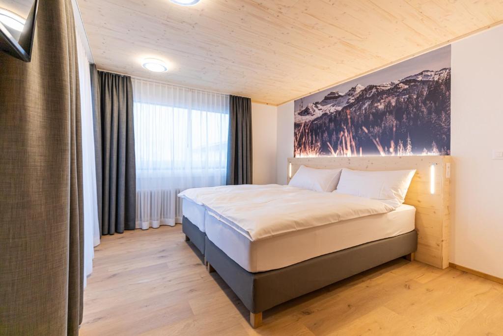 1 dormitorio con 1 cama con una pintura en la pared en Roggenstock Lodge, en Oberiberg