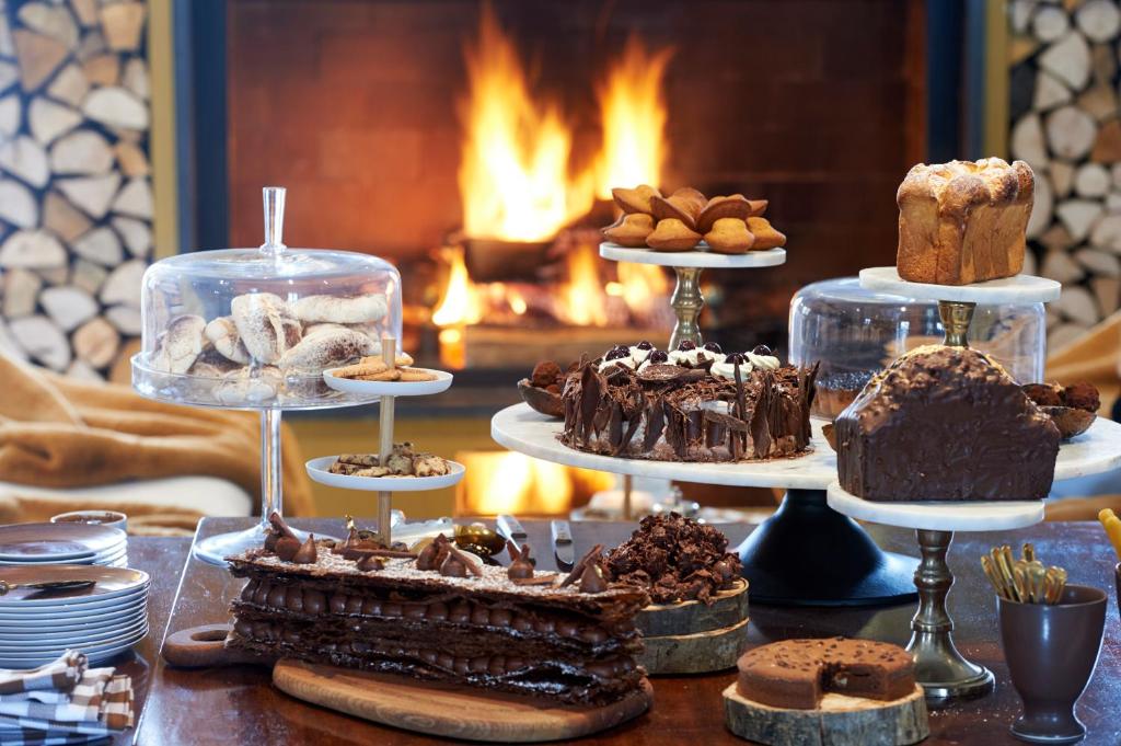 a table with cakes and other desserts on display at Grand Hotel Soleil d'Or in Megève