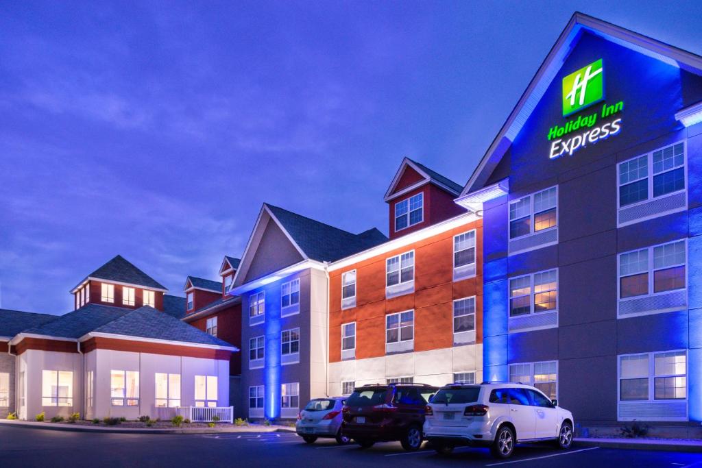 a hotel with cars parked in a parking lot at Holiday Inn Express Mystic, an IHG Hotel in Mystic