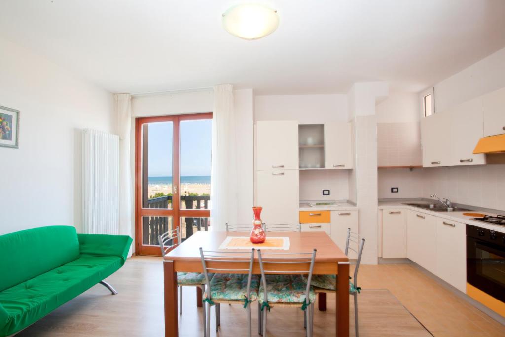 eine Küche und ein Esszimmer mit einem Tisch und einem grünen Sofa in der Unterkunft Residence Rizzante in Caorle
