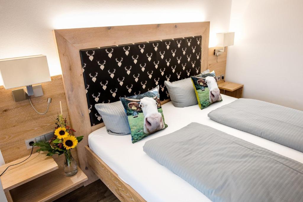 a bedroom with two beds with pillows and a headboard at Landhotel Böld Oberammergau in Oberammergau