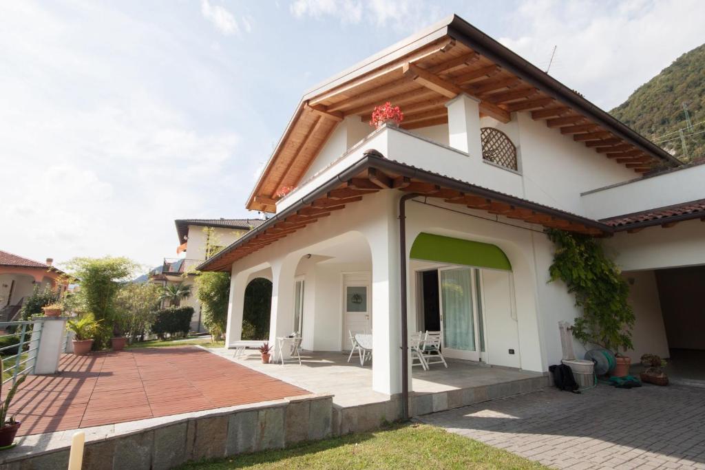 a white house with a porch and a patio at Villa 3 Olivi - sleep 5 - in Lenno in Lenno
