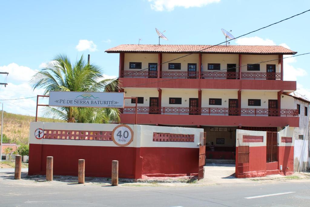 ein rotes Gebäude mit einem Schild davor in der Unterkunft Pousada Pé de Serra Baturité in Baturité