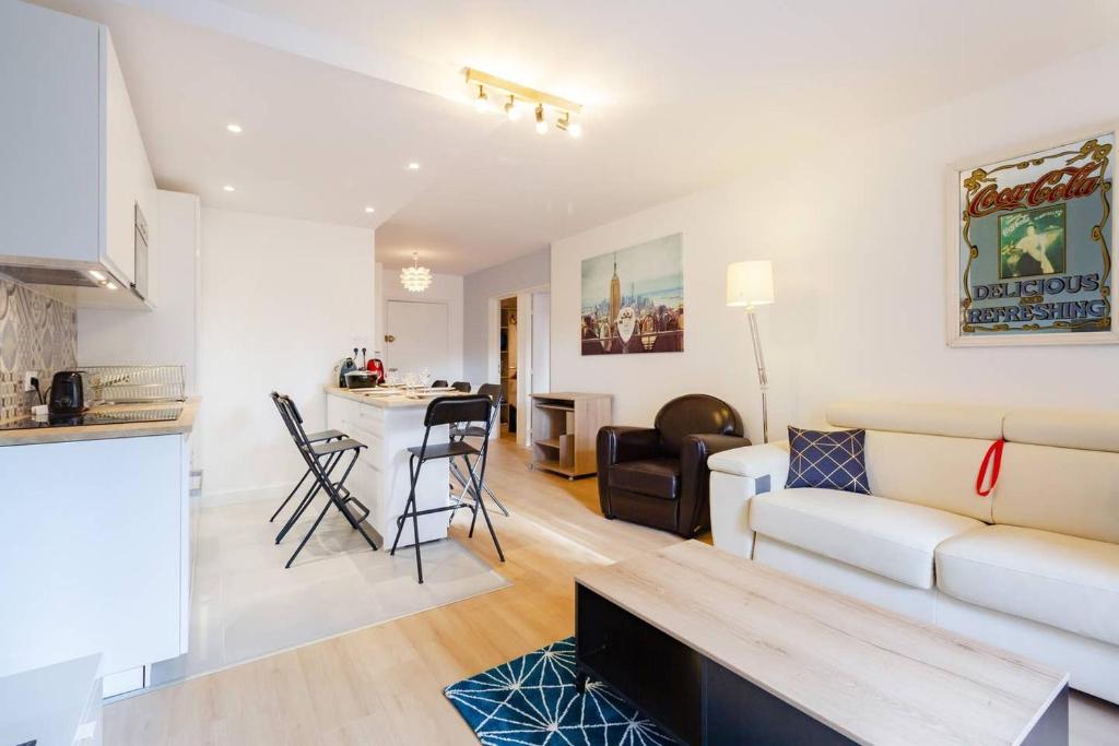 un salon et une cuisine avec un canapé et une table dans l'établissement 2 chambres Terrasse Parking Toulouse Centre Gare, à Toulouse