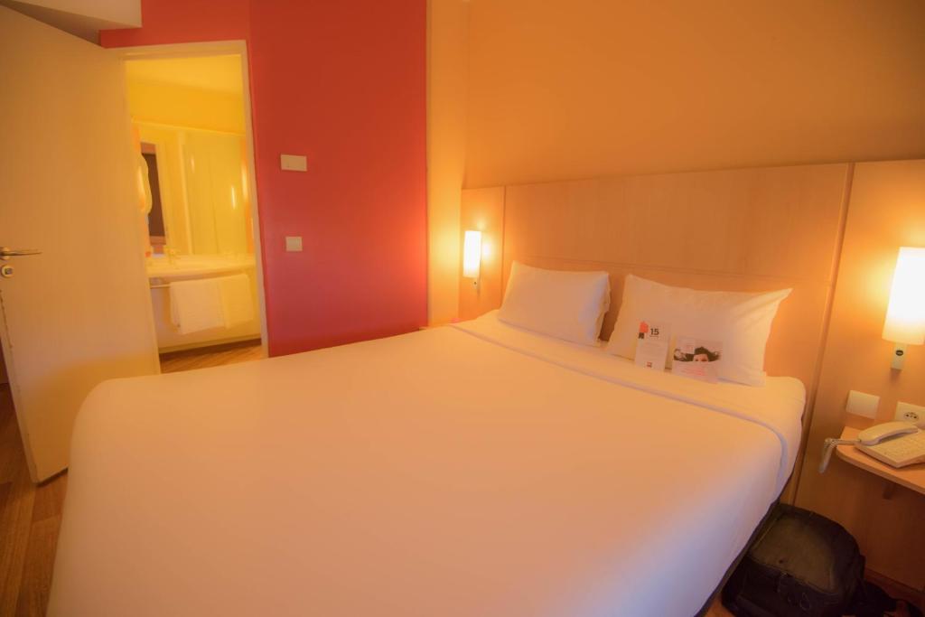 a bedroom with a large white bed with two pillows at ibis Alger Aéroport in Alger