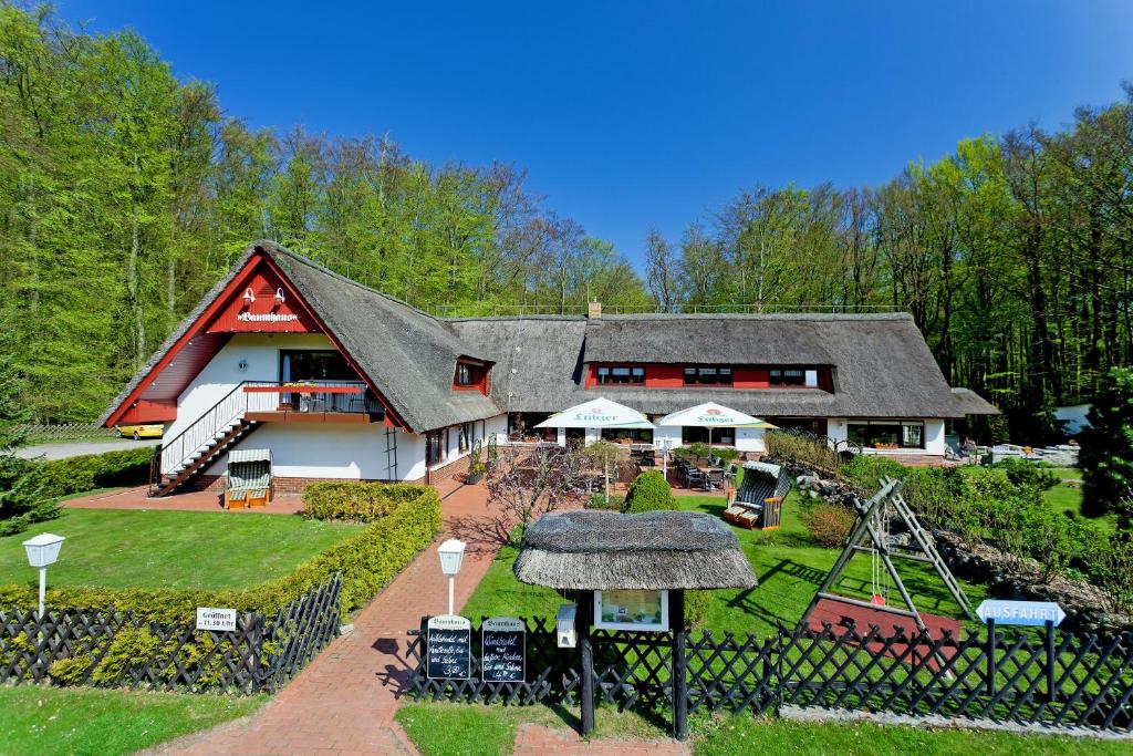 uma casa grande com um parque infantil em frente em Restaurant & Hotel Baumhaus Hagen em Sassnitz