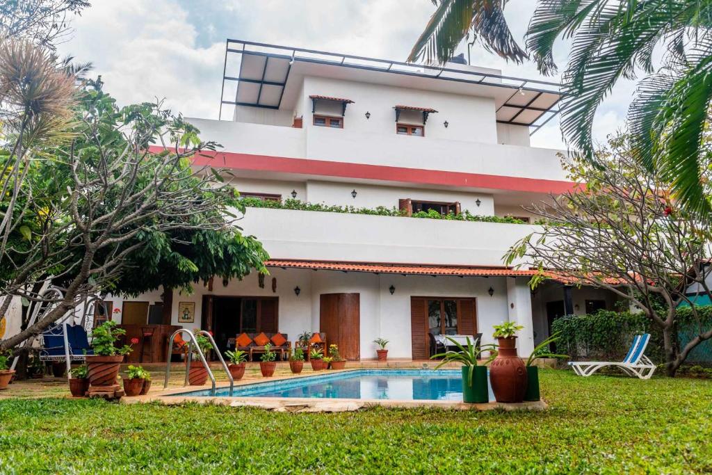 a house with a swimming pool in front of it at StayVista at Firefly Homestay with Pvt Pool & Terrace Access in Bangalore