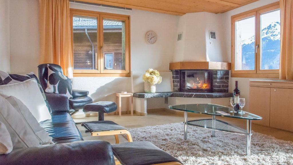 uma sala de estar com um sofá e uma lareira em Chalet Millennium em Wengen