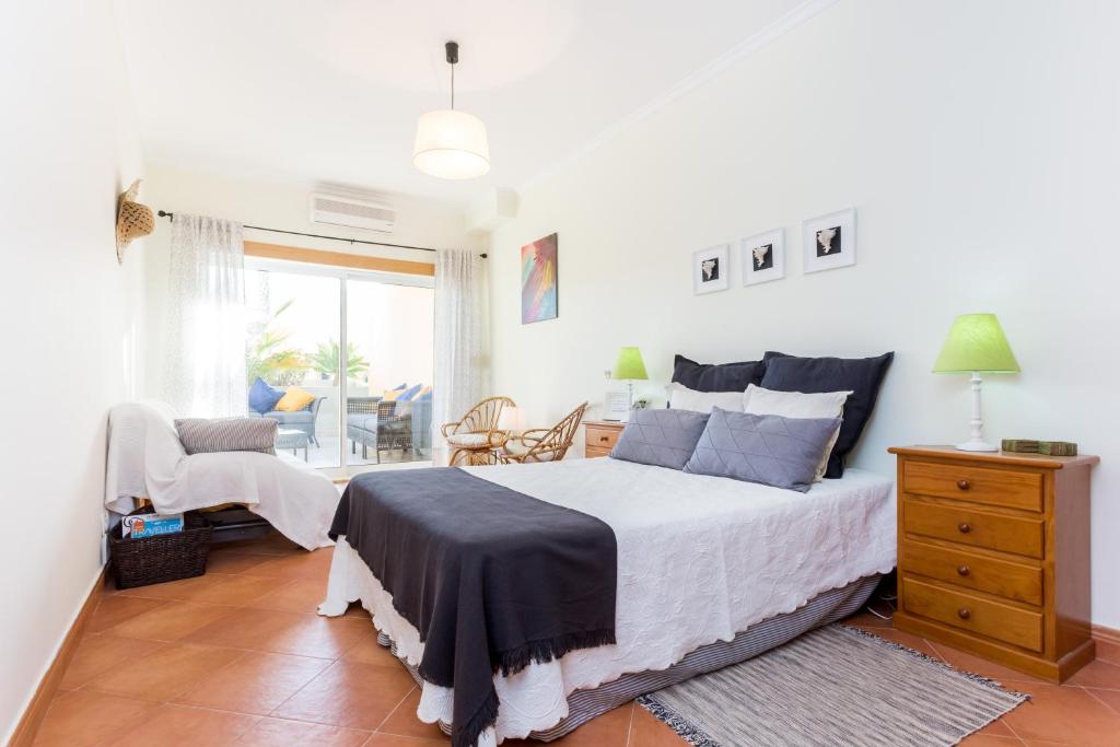 een slaapkamer met een bed, een stoel en een raam bij IM On Meia Praia Terrasse in Lagos