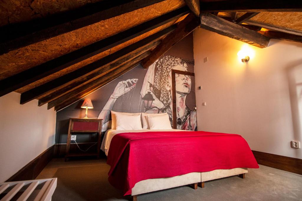 um quarto com uma cama vermelha num sto em Casa com Historia na Covilh