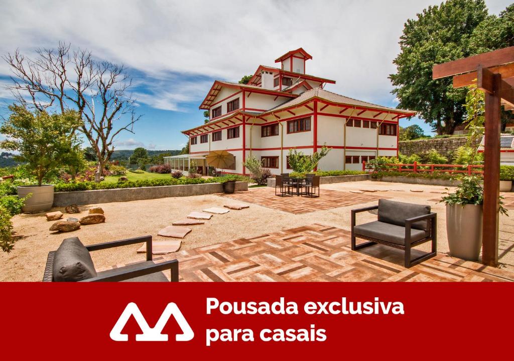 a large house with a patio in front of it at Matsubara Pousada in Campos do Jordão
