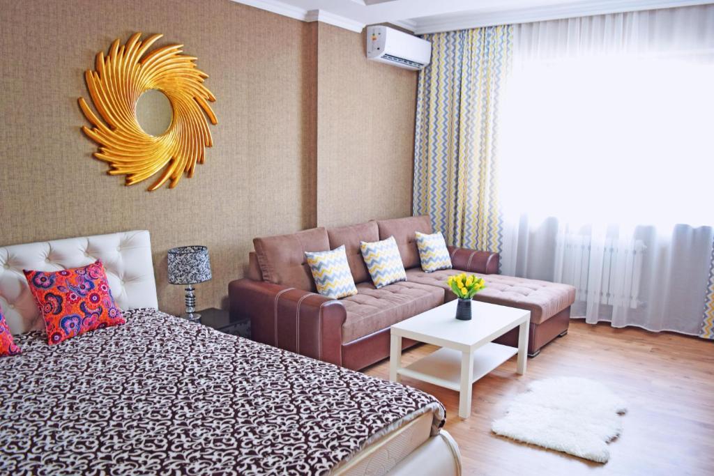 een woonkamer met een bed en een bank bij Bishkek Sunny Apartment in the center in Bisjkek
