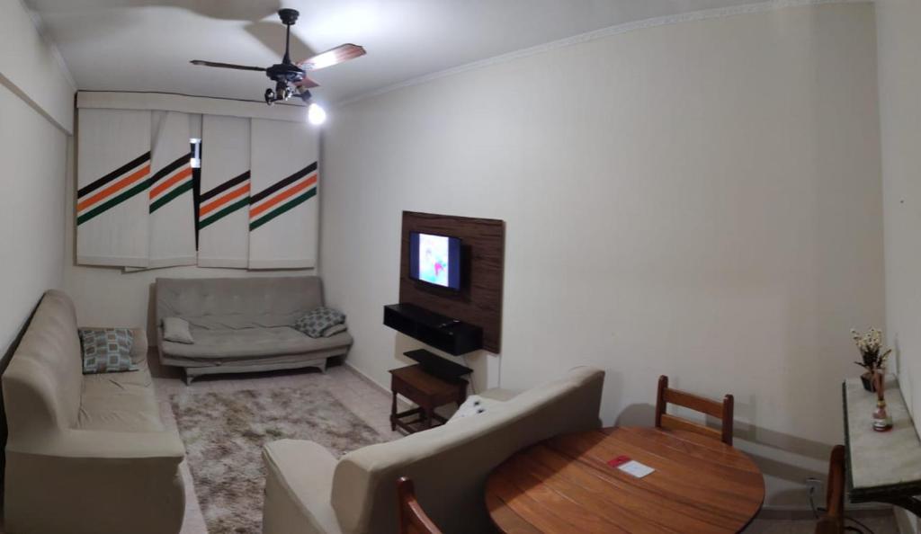 a living room with a table and a couch at Casa Gomes in Praia Grande