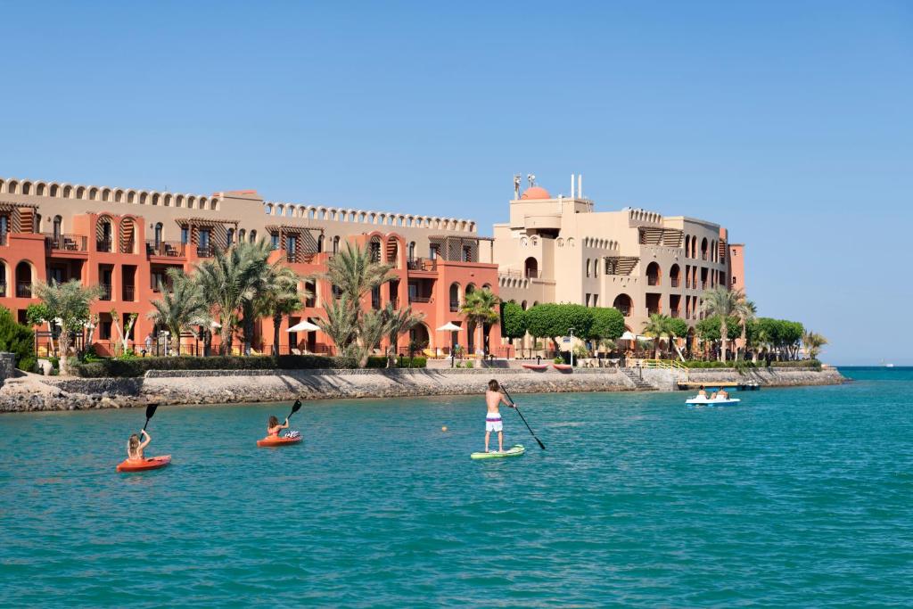 Three Corners Ocean View El Gouna - Adults Only في الغردقة: مجموعة من الناس على ألواح التجديف في الماء