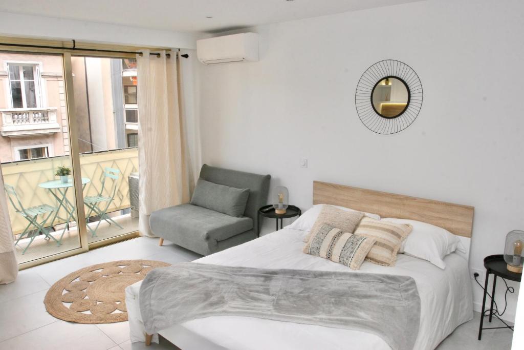 1 dormitorio con 1 cama, 1 silla y 1 ventana en Le Melsono Carré d'Or, en Niza