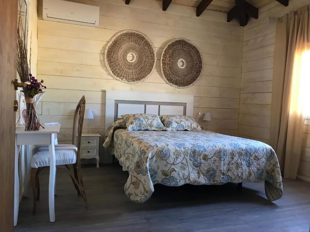 a bedroom with a bed and a table with a chair at Casa rural Vega alta in Madridejos