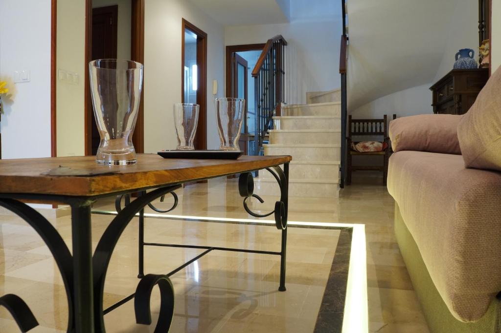 a living room with a table with glasses on it at Dúplex Centro Parking Ronda in Ronda