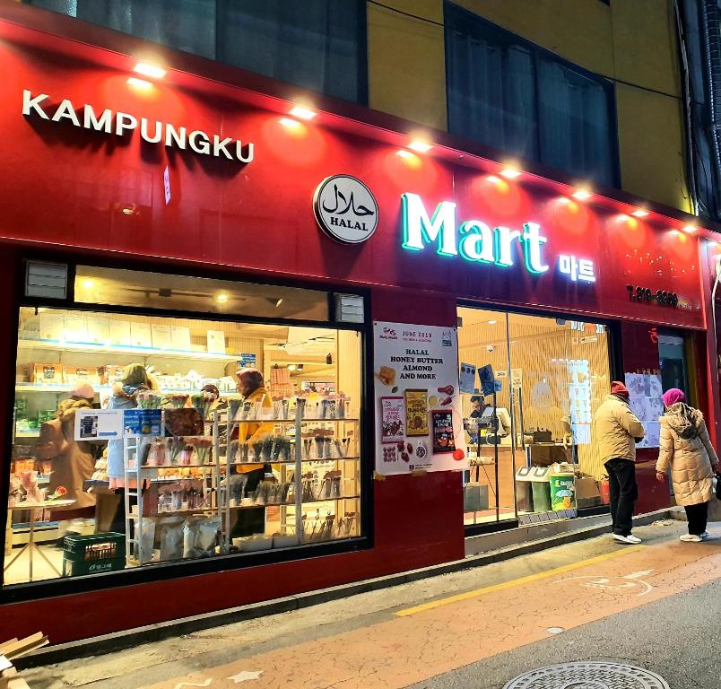 a man and woman standing outside of a mart store at Happy Garden Guesthouse in Seoul