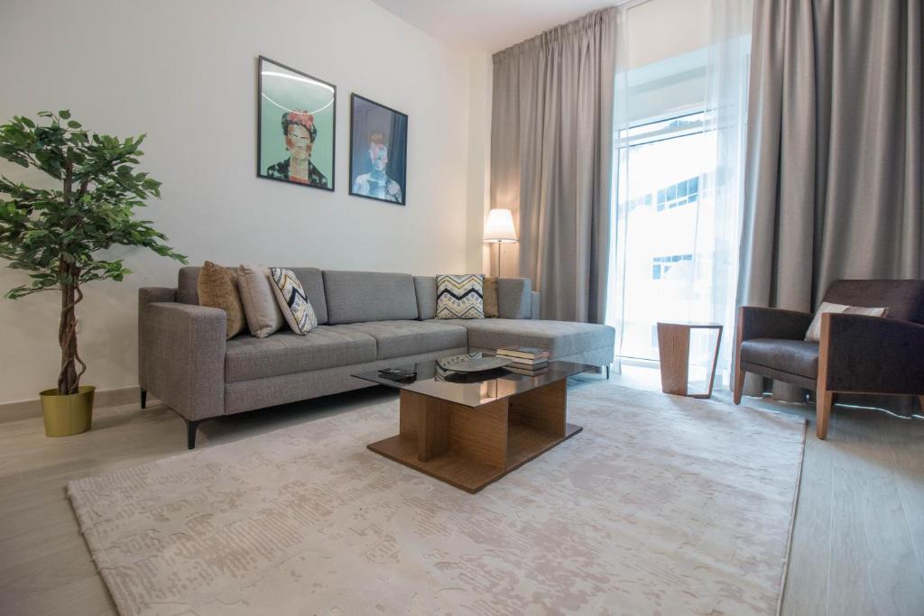 a living room with a couch and a coffee table at In Healthcare City, Newly Furnished, 1BR Azizi Aliyah in Dubai
