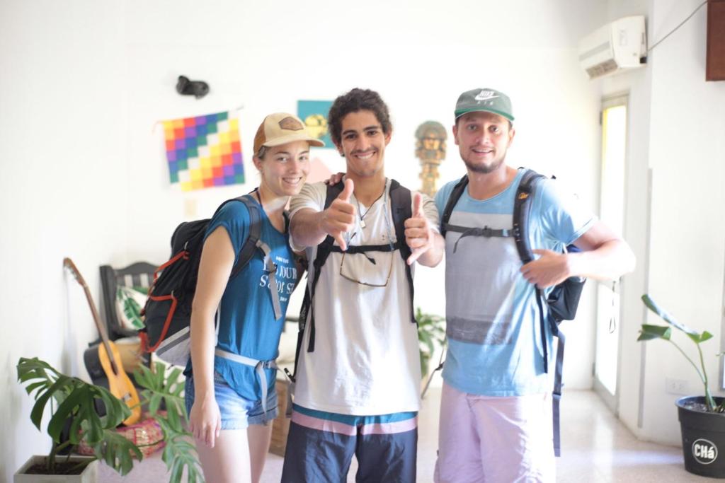 een groep van drie personen die poseren voor een foto bij Hostel Cha in Resistencia