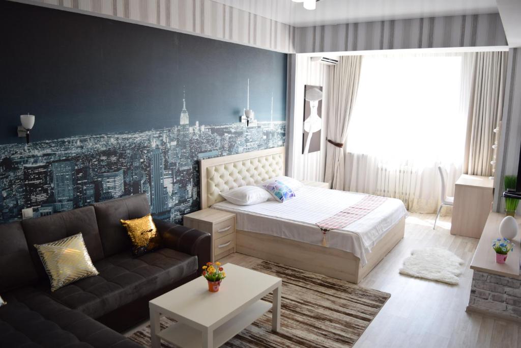 1 dormitorio con 1 cama y 1 sofá en Studio boutique apartment, en Bishkek