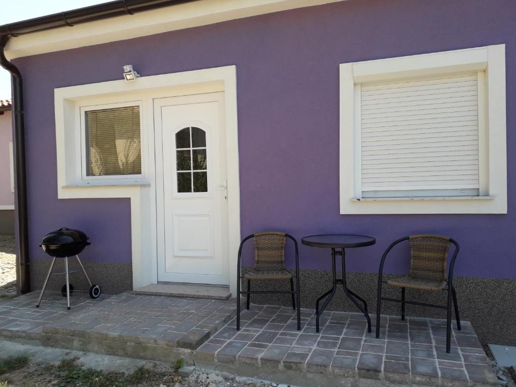 Maison violette avec 2 chaises et une table à côté d'une porte dans l'établissement Sorily, à Koper