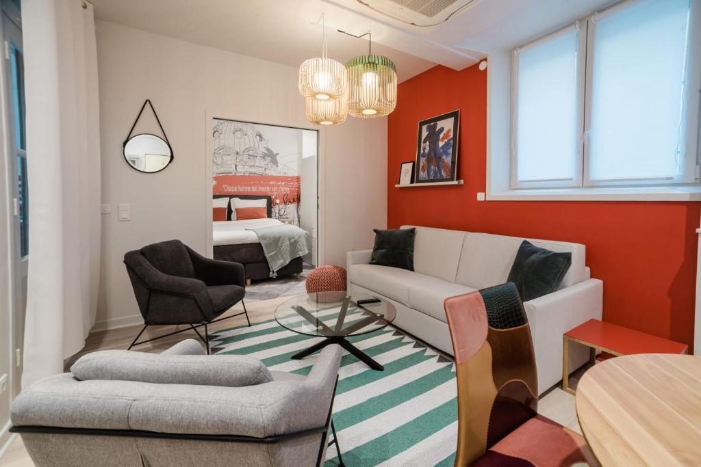 パリにあるSUITE SARTRE : au cœur de la Rive Gauche, neuf, design, 2/4 personnesのリビングルーム(ソファ、椅子付)、ベッドルーム1室が備わります。